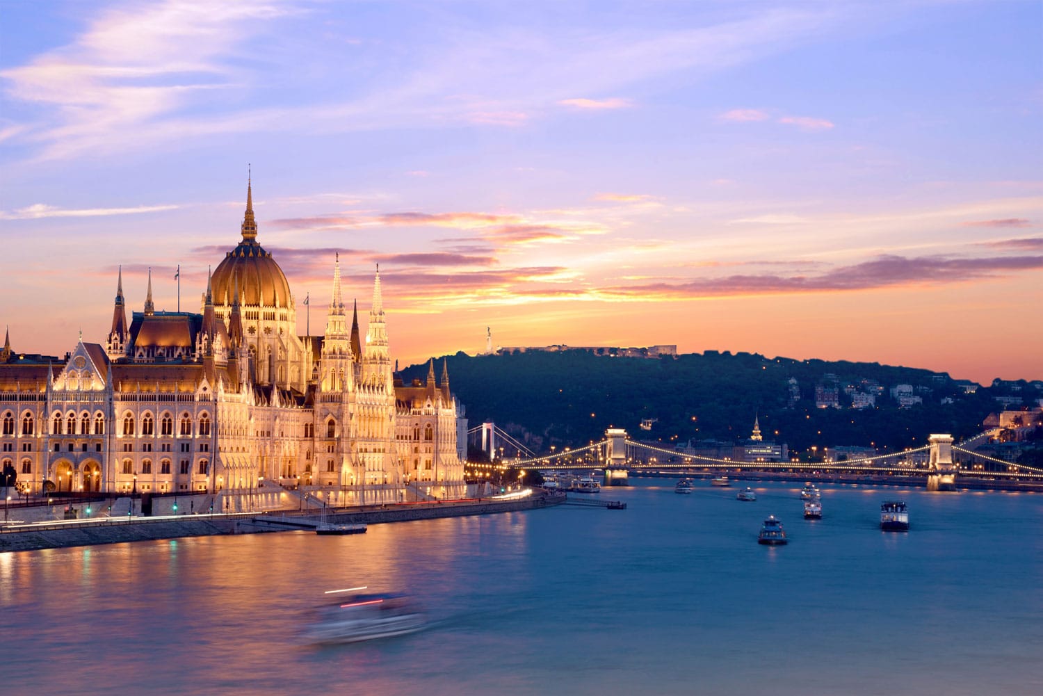 The picturesque landscape of the Parliament and the bridge over the Danube in Budapest at sunset