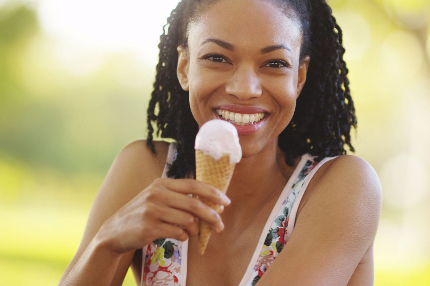 Black woman smiling and eating ice cream