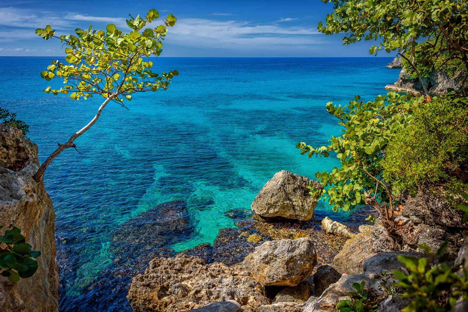 Beautiful turquoise and blue water near rocks and cliffs in Negril, Jamaica.