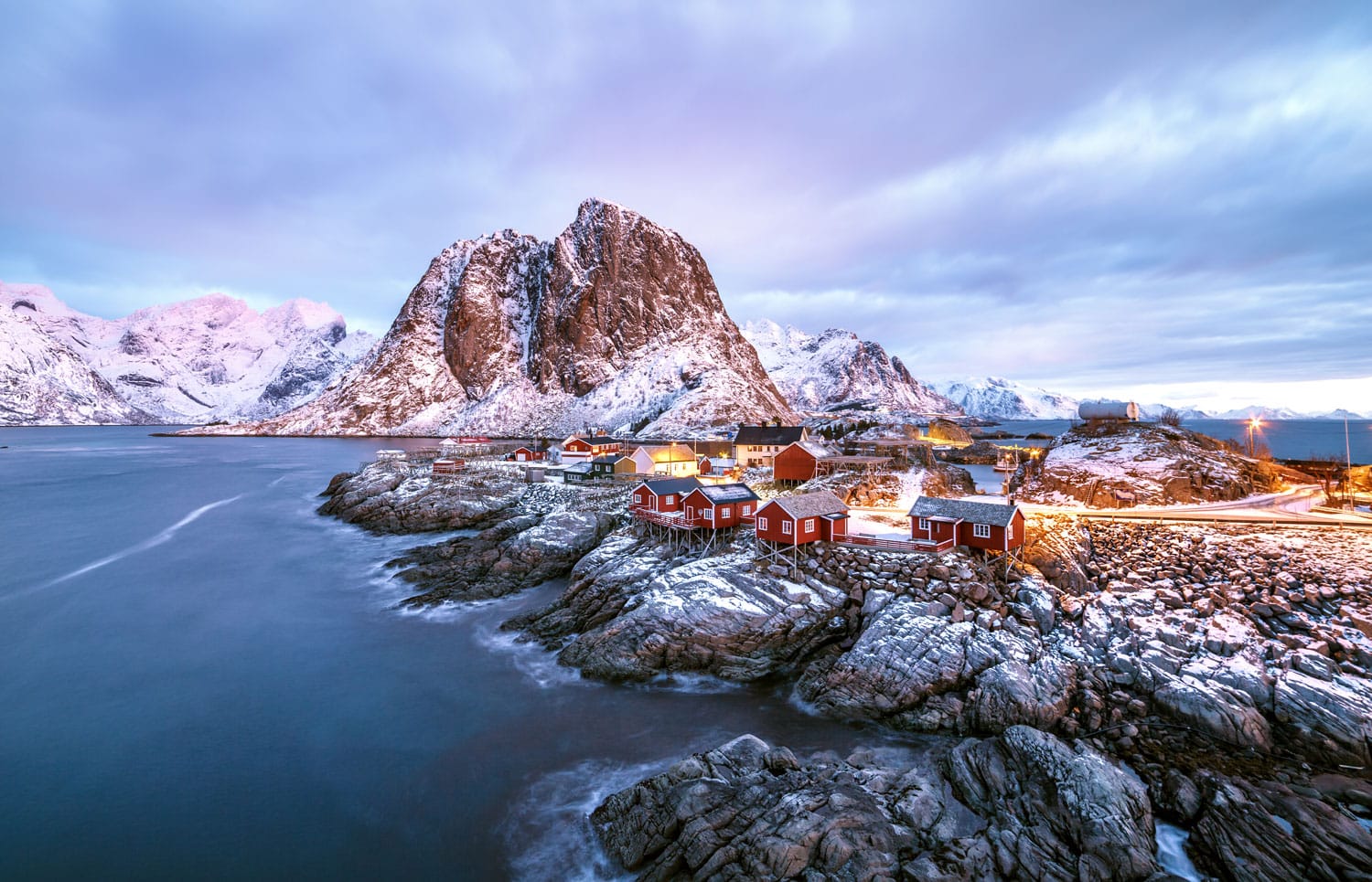 Fishing hut (rorbu) in the Hamnoy and Lilandstinden mountain peak at sunset - Reine, Lofoten islands, Norway