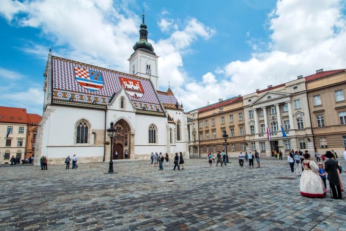 St Mark's Square in Zagreb, Croatia, surrounded by tourists. St Mark's square is political center of Croatia and popular tourist location.