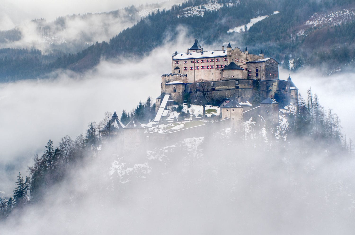 Castle Hohenwerfen by Salzburg high over clouds on a misty mountain in the Alps