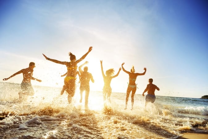 Crowd of people running into the sea