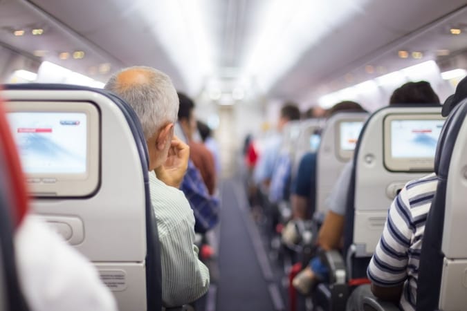 Interior of airplane with passengers on seats waiting to take off.