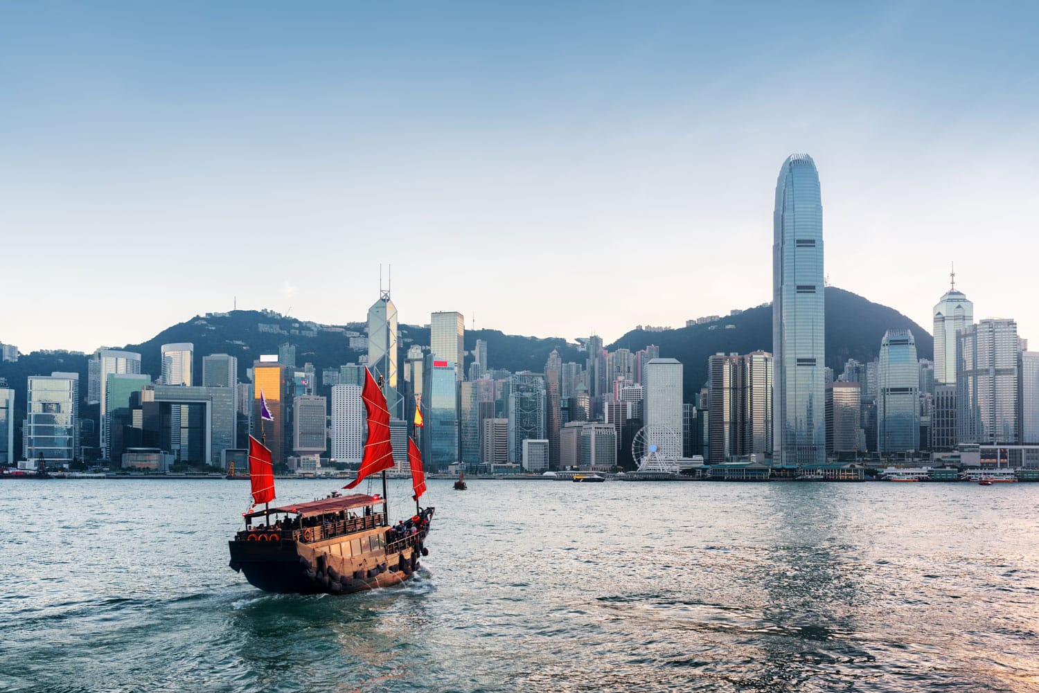 Tourist sailboat crosses Victoria harbor from Kowloon side to the Hong Kong Island