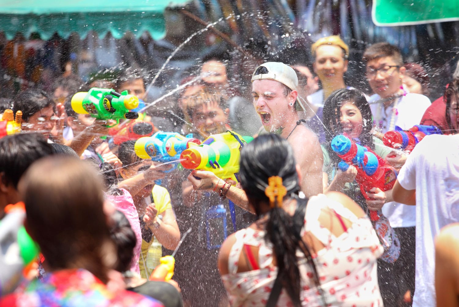Tourists shooting water guns and having fun at Songkran festival, the traditional Thai New Year, on Khao San Road in Bangkok, Thailand.
