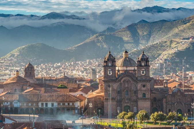 Morning sun rising at Plaza de armas with Adean Moutain and group of cloud, Cusco, Peru