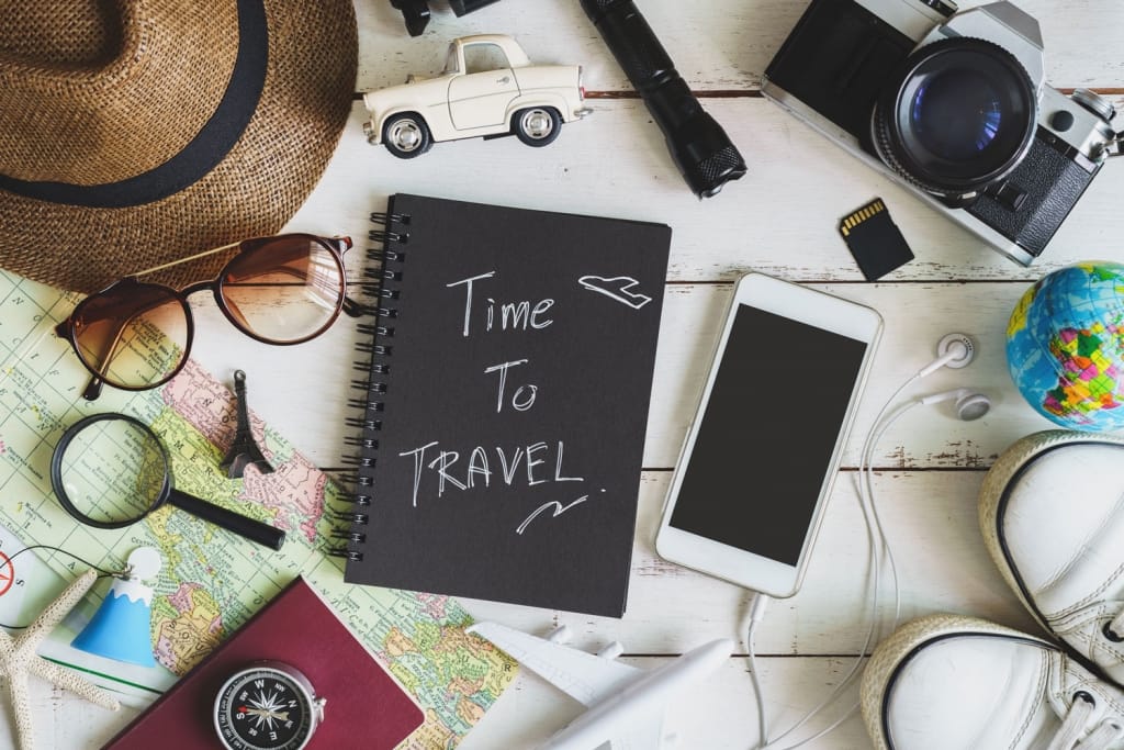 Overhead view of Traveler's accessories and items with black notebook and copyspace