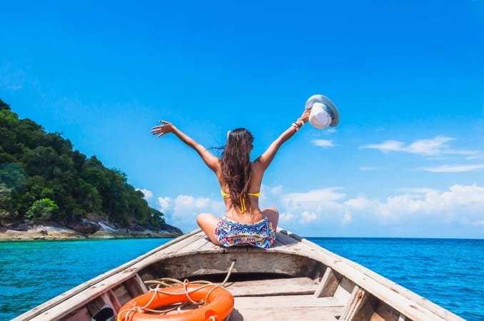 woman in bikini relaxing on wooden boat