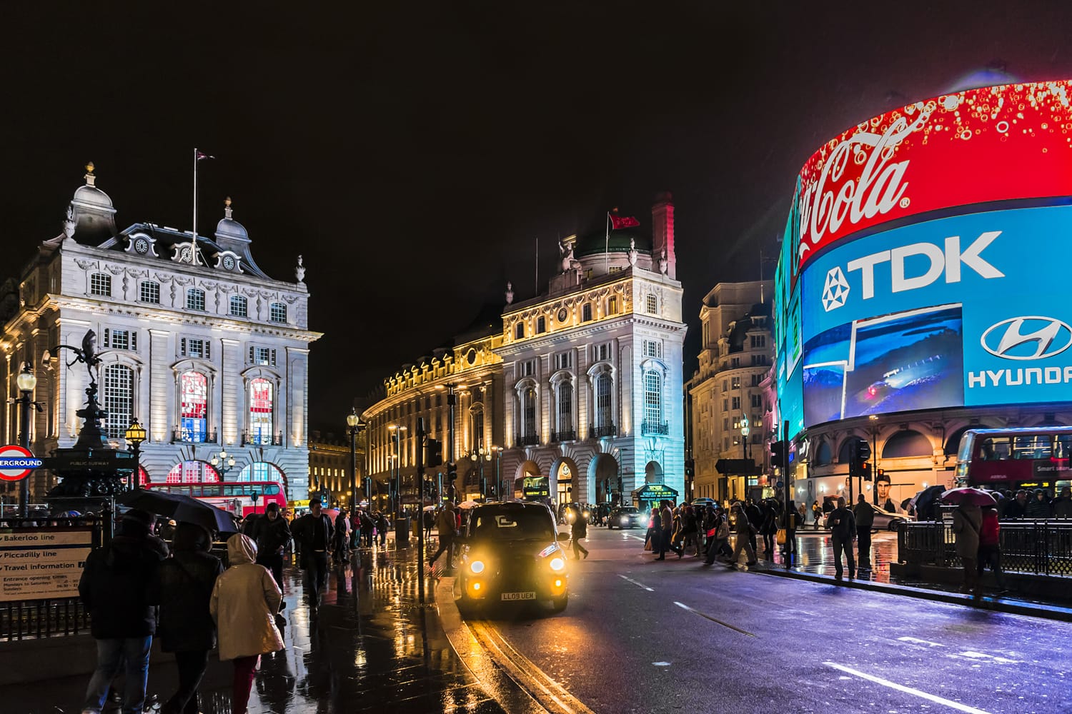 Famous Piccadilly Circus neon signage shines at rainy night. These signs have become a major attraction of London, United Kingdom