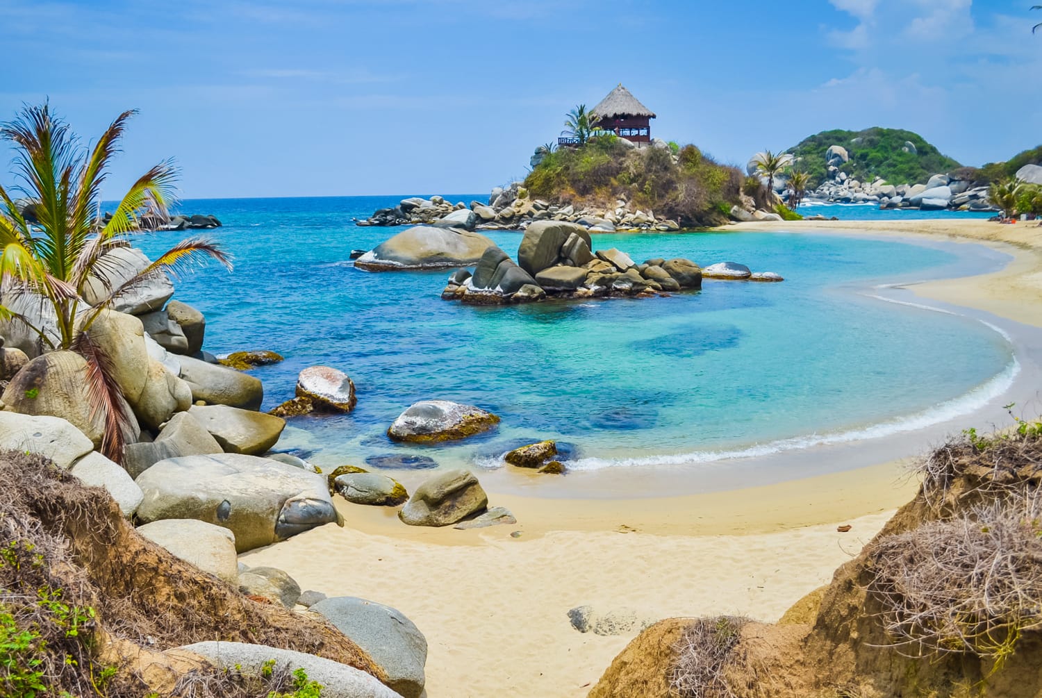 Beautiful bay with white sand beach, blue water and big boulders in Tayrona national park in Colombia