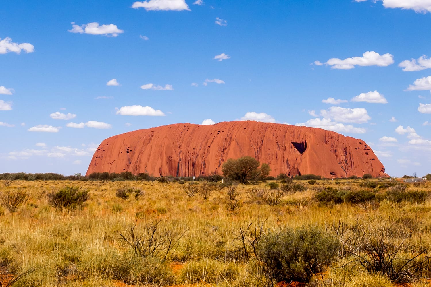 Uluru under late afternoon sky in Uluru-Kata Tjuta National Park. The sandstone rock formation is one of Australias most famous sights.