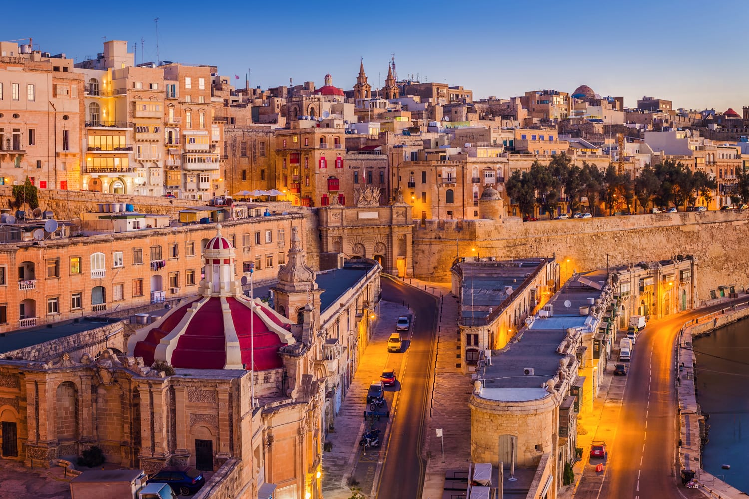 Valletta, Malta - The traditional houses and walls of Valletta, the capital city of Malta on an early summer morning before sunrise with clear blue sky