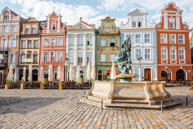 View on the beautiful old buildings with Neptune fountain on the Maket square in Poznan city during the morning light in Poland