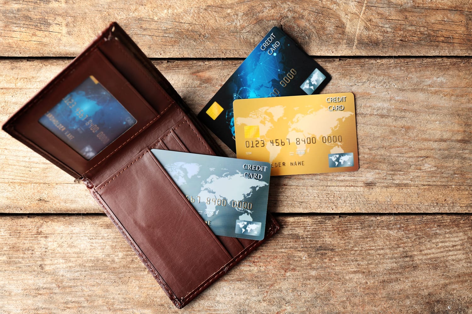 Credit cards in leather wallet on wooden background