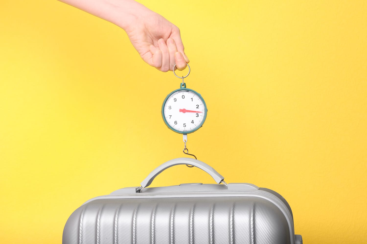 Woman weighting heavy luggage