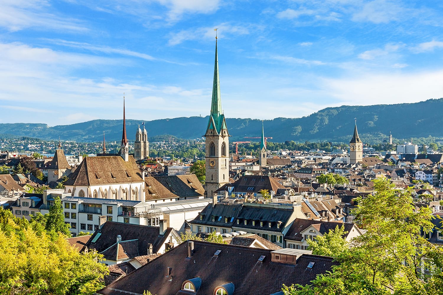 Zurich downtown - famous Minster Fraumunster in front, Minster Grossmunster and church St. Peter. View from Polyterrace (Polyterrasse) at University of Zurich (Eidgenossische Technische Hochschule)