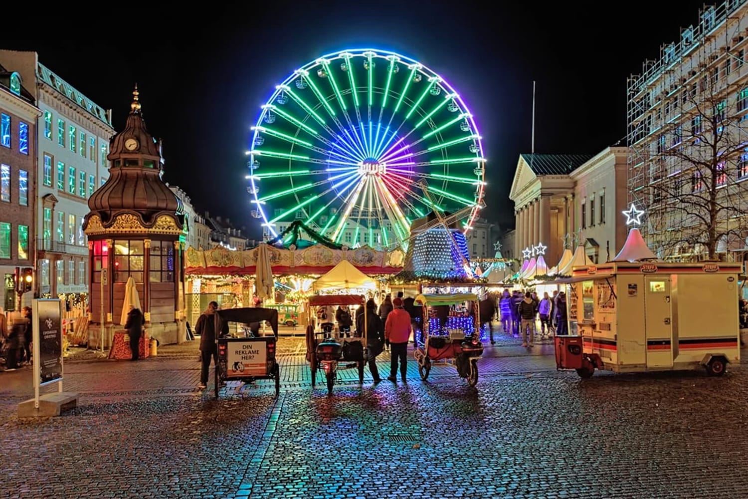 Christmas market with Ferris wheel on the Nytorv square in evening