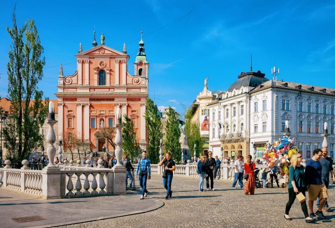 People at Franciscan Church of the Annunciation and Triple Bridge in the historical center of Ljubljana, Slovenia
