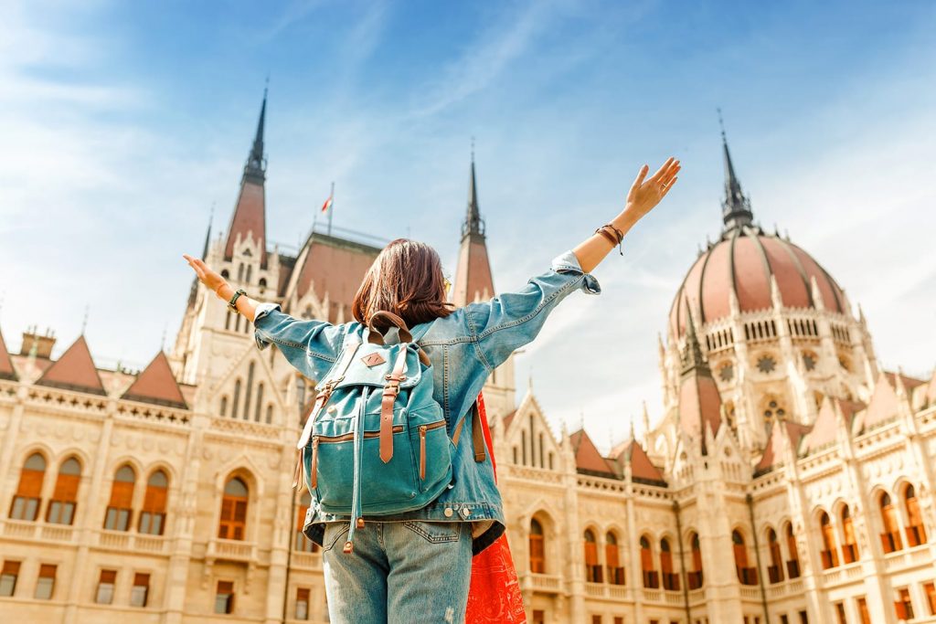Happy asian casual woman student enjoying great view of the Parliament building in Budapest, Hungary