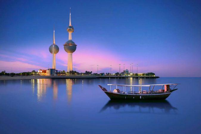 Arabian passenger boat during blue hour next to kuwait tower