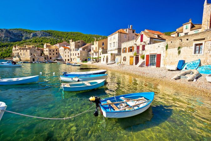 Scenic beach in Komiza village waterfront, Island of Vis, Croatia