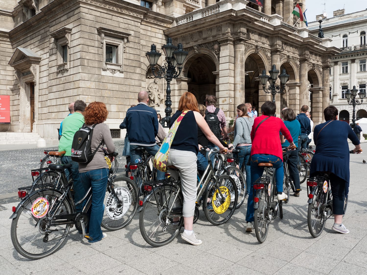Tourists on rented bikes in front of the Opera House on Andrassy Avenue in Budapest, Hungary