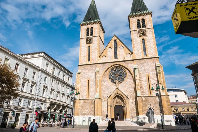 The Cathedral of Jesus' Sacred Heart in Sarajevo, Bosnia and Herzegovina, on a sunny day with people in the street