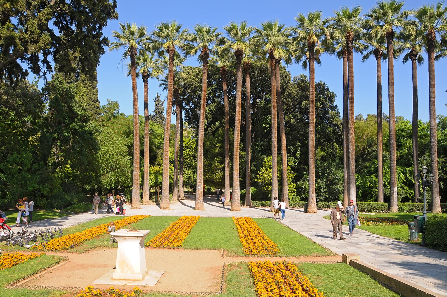 People walking among the paths of the National Garden in Athens, Greece