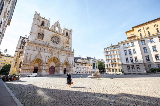 Morning view on the saint John cathedral with woman walking on the square in the old town of Lyon city