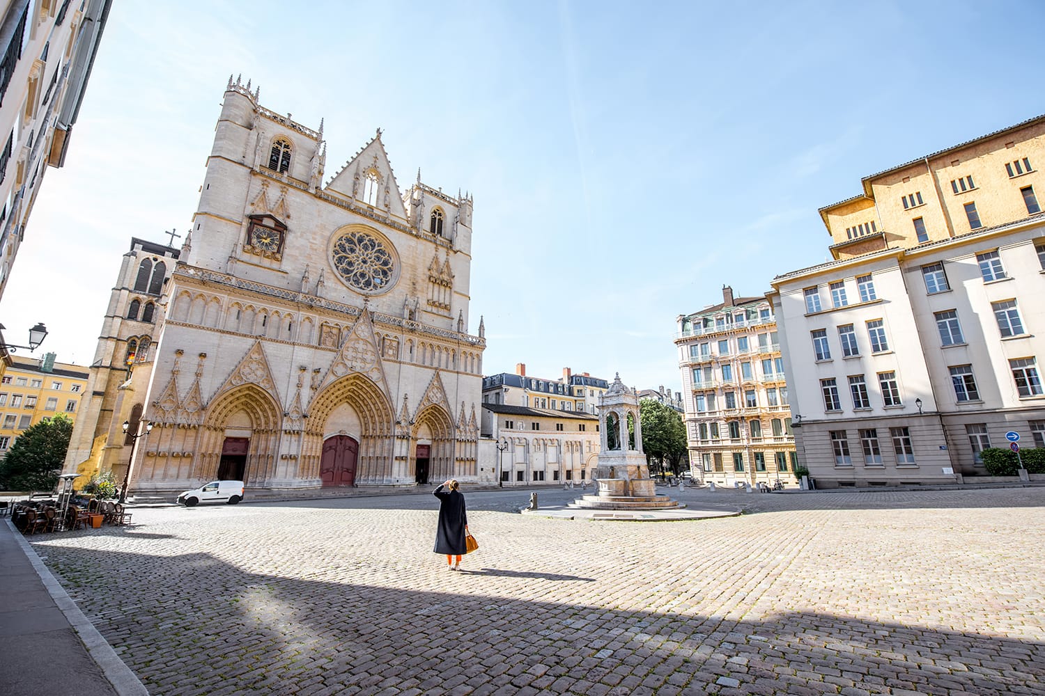 Morning view on the saint John cathedral with woman walking on the square in the old town of Lyon city