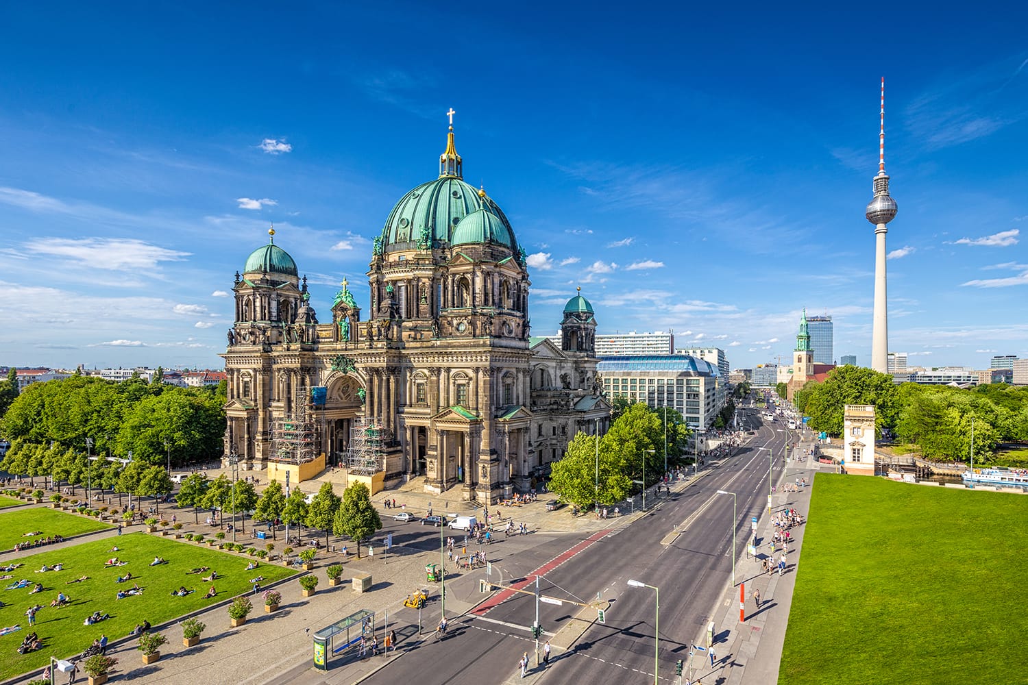 Aerial view of Berlin Cathedral at Lustgarten park with famous TV tower in the background on a sunny day with blue sky and clouds in summer, Berlin Mitte district, Germany