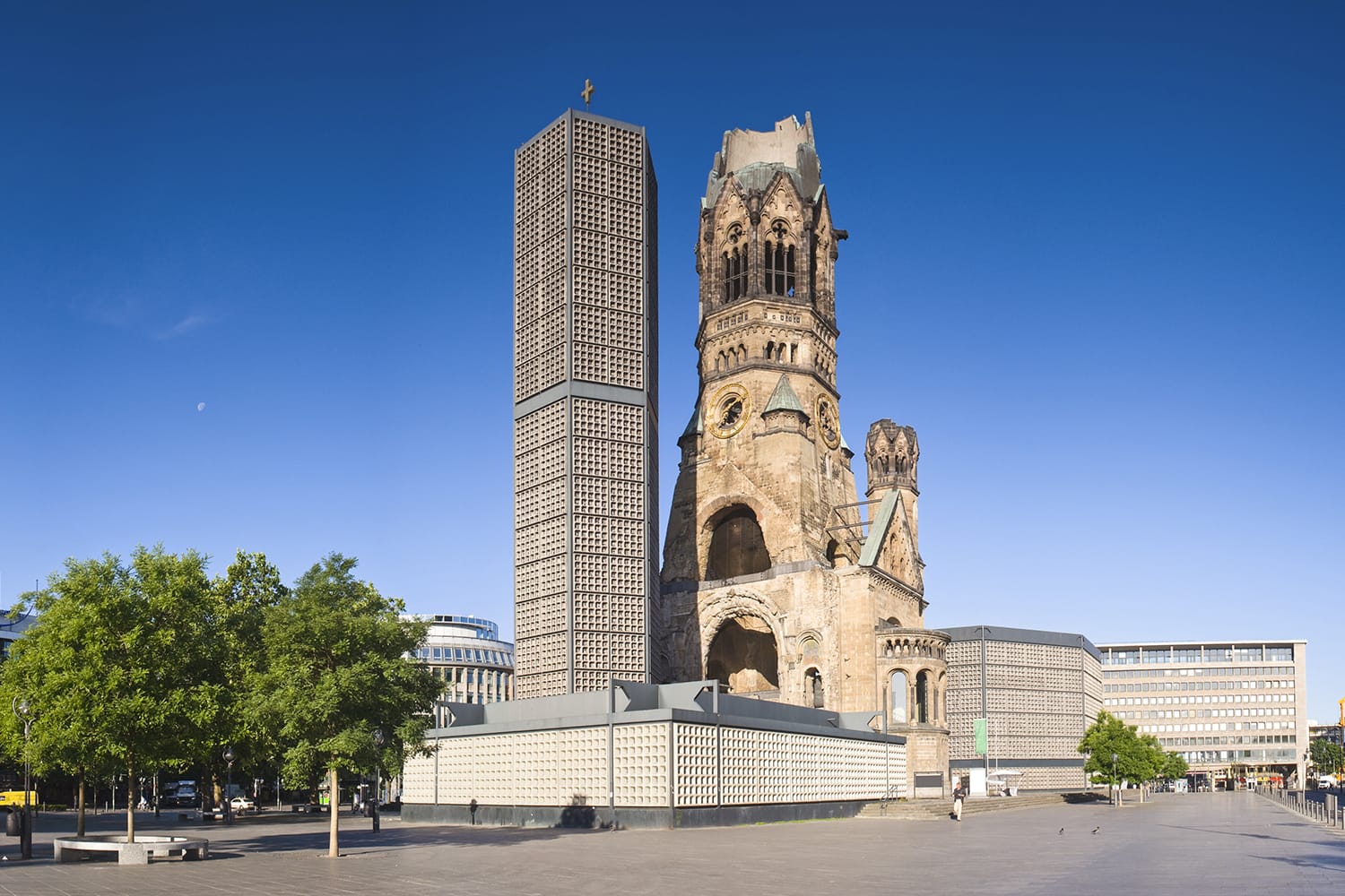 Kaiser-Wilhelm-Kirche, broken spire and modern bell tower overlook the busy Breitscheidplatz as symbols of the city's regeneration.