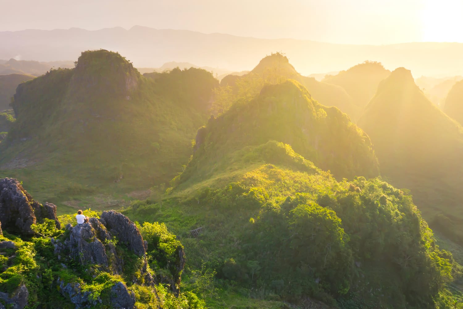 Young man enjoying sunset on Osmena Peak in South Cebu, Philippines