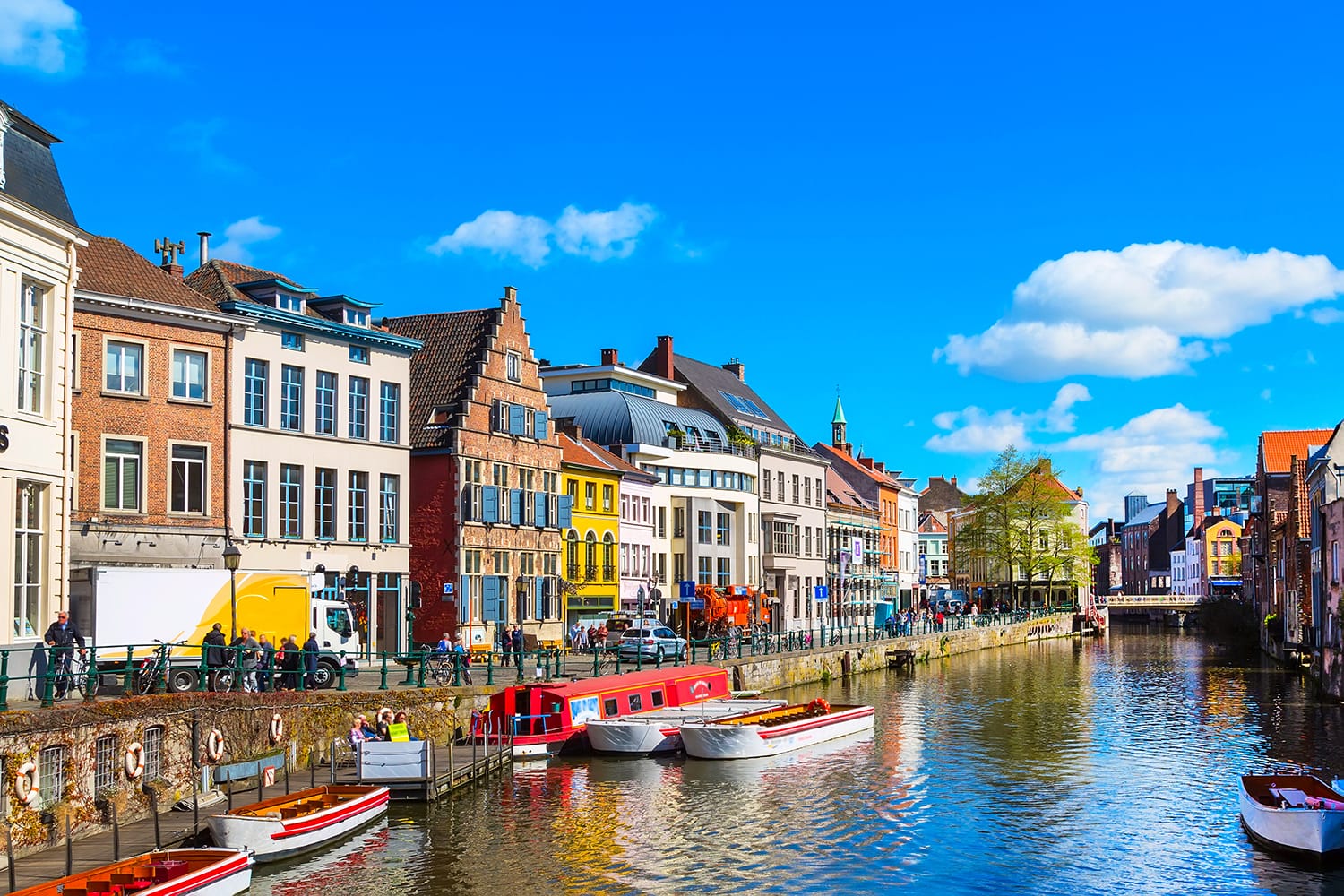 Old colorful traditional houses along the canal and boats in popular touristic destination Ghent, Belgium