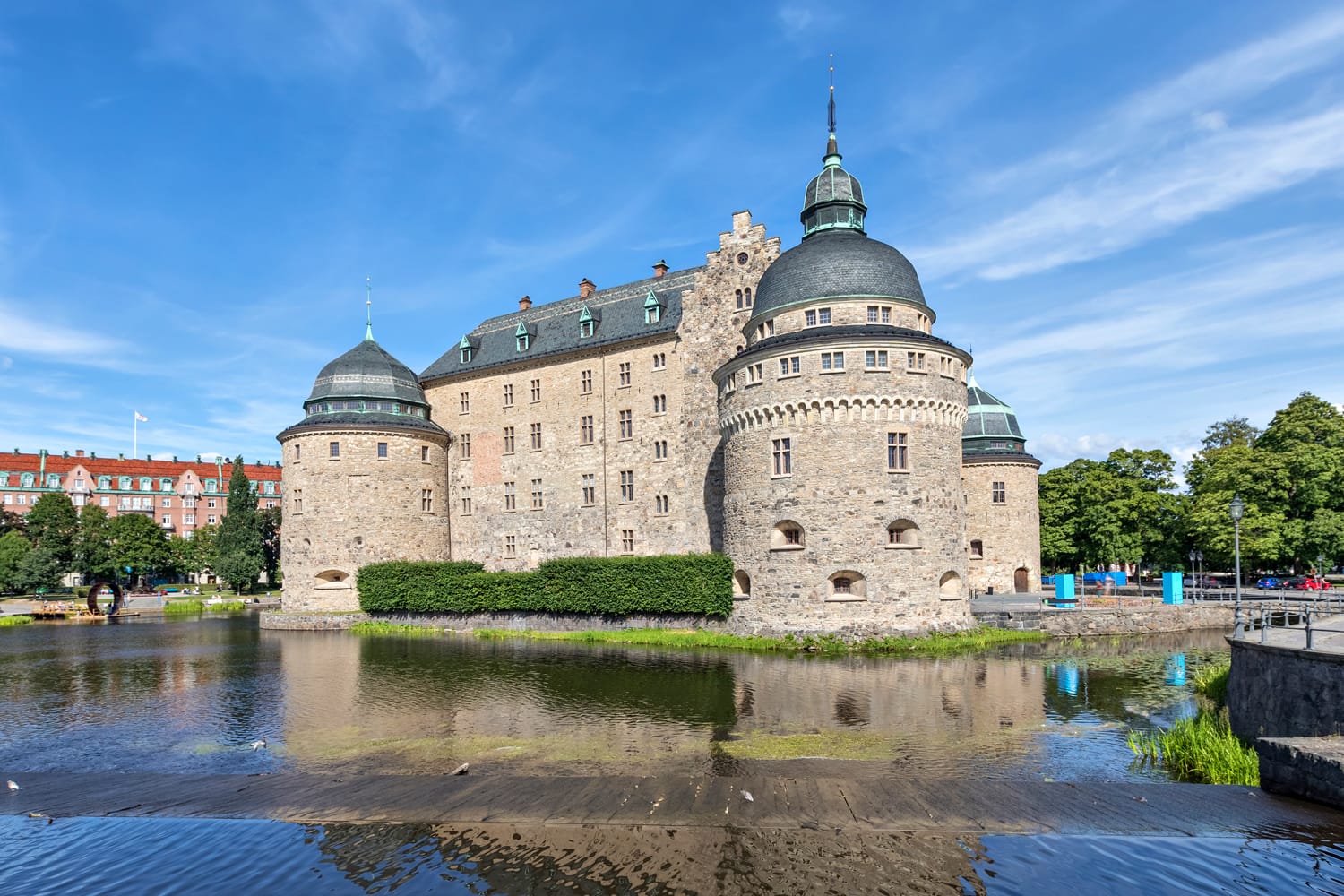 Orebro castle reflecting in water on sunny summer day in city Orebro, Sweden