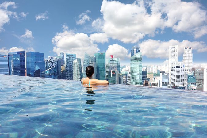 Attractive woman relaxing in Marina Bay Sands infinity swimming pool, Singapore