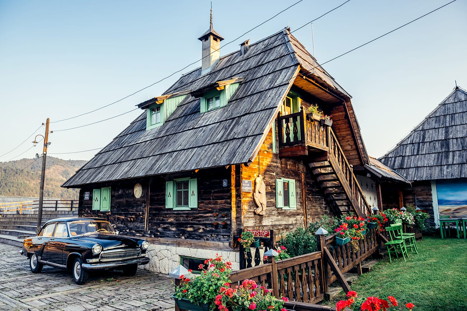 Old Volga car in front of wooden house of Drvengrad village built by Emir Kusturica in Serbia
