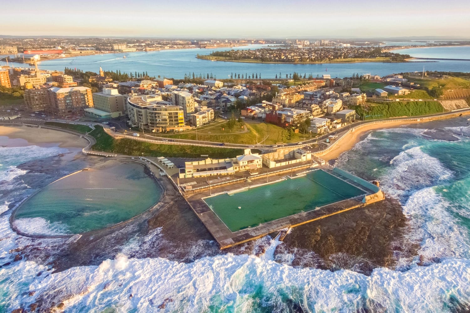 Aerial shot of sun rising over the Newcastle Ocean Baths, NSW, Australia