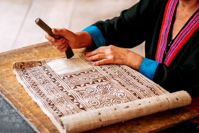 Hilltribe Laotian woman working on Batik fabric painting. Culture tourism at Ock Pop Tok handicraft center, Luang Prabang, Laos