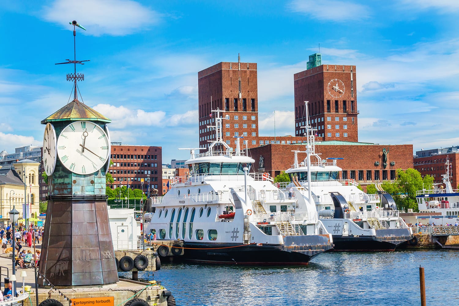 Clock on Aker Brygge Dock, modern and very popular part of Oslo in the background of the famous Oslo City Hall and the harbor, Oslo Fjord, Norway, Scandinavia