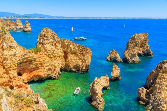 Fishing boat on turquoise sea water at Ponta da Piedade, Algarve region, Portugal