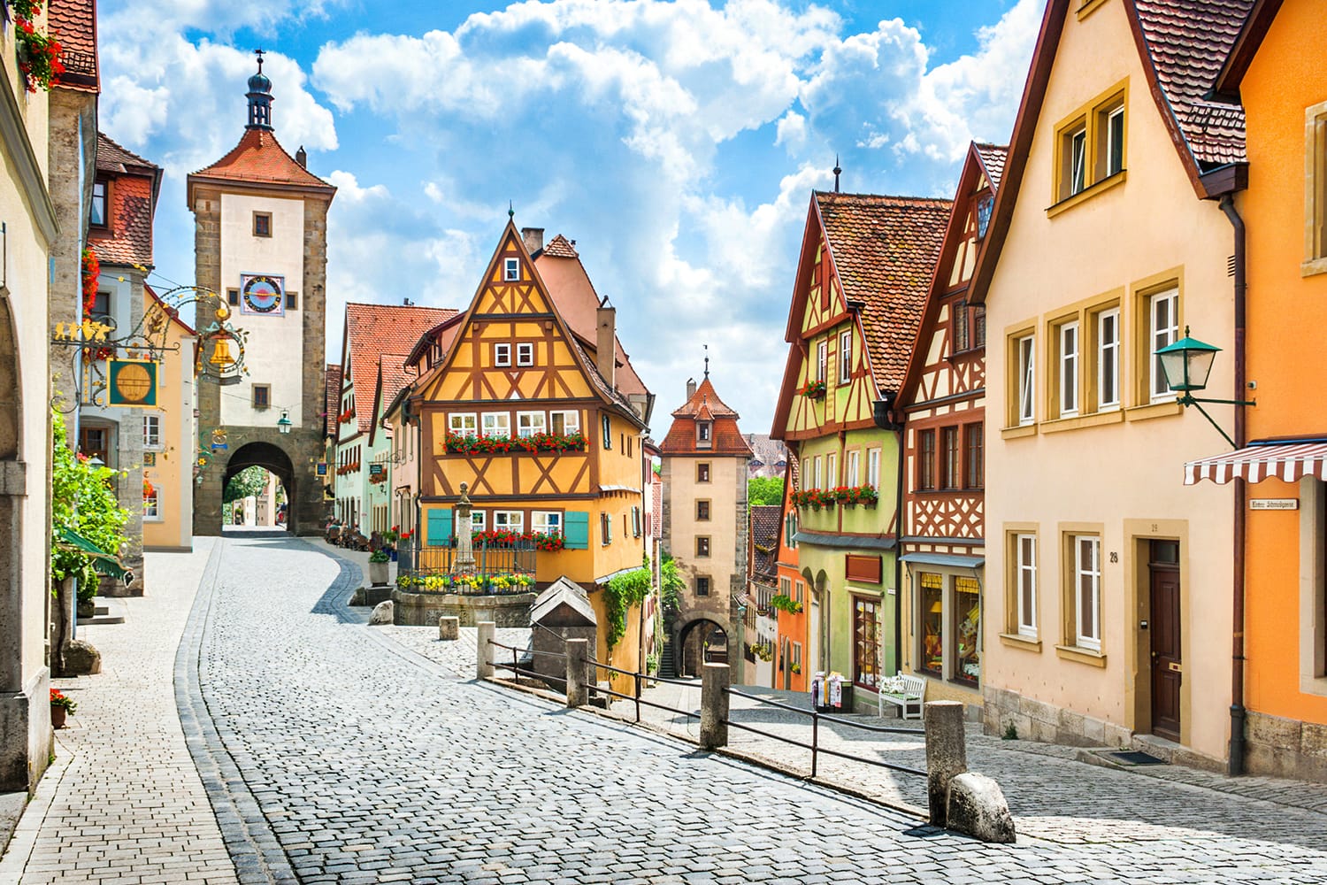 Beautiful postcard view of the famous historic town of Rothenburg ob der Tauber on a sunny day with blue sky and clouds in summer, Franconia, Bavaria, Germany