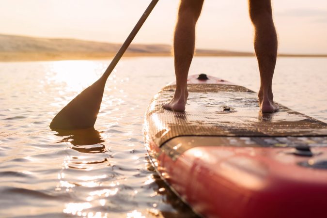 Person on paddle board at sunset