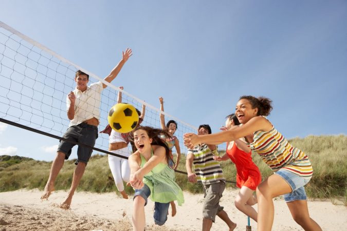 Group Of Teenage Friends Playing Volleyball On Beach