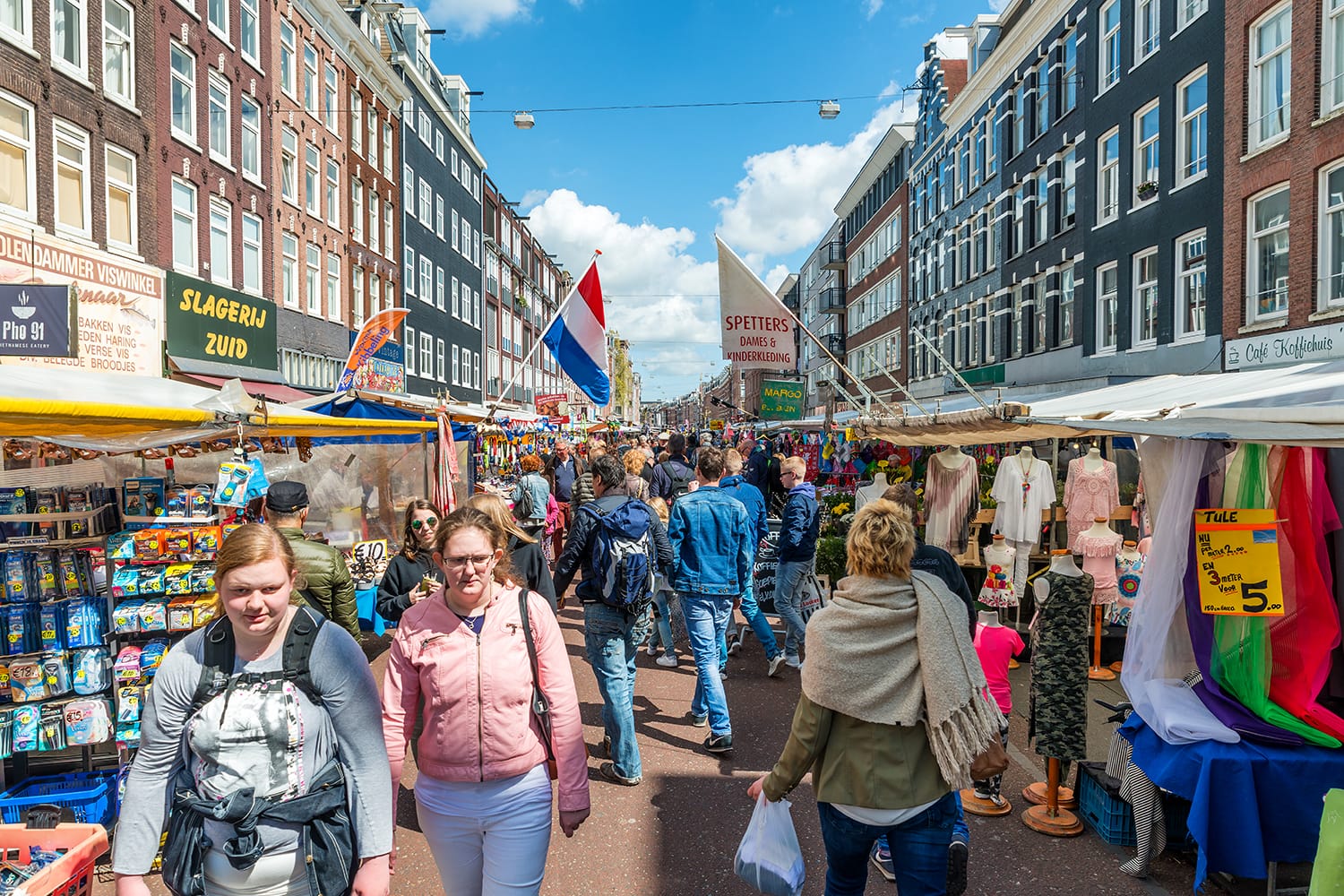 Tourists walk in Albert Cuyp Market. Albert Cuyp Market is one of sights of the city in Amsterdam, Netherlands