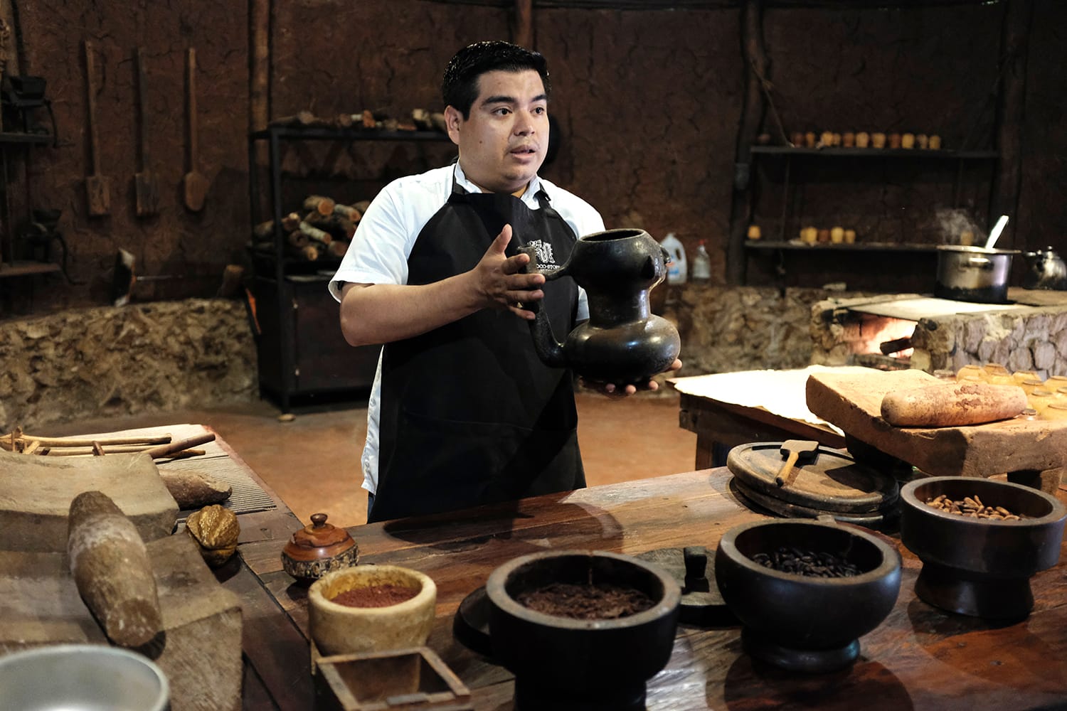 A local Mexican staff at the Chocolate museum explaining the process of how to make a Mayan chocolate drink from cocoa beans.