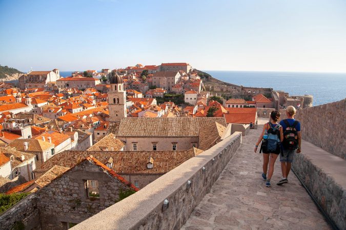 Couple walking on wall in Dubrovnik, Croatia