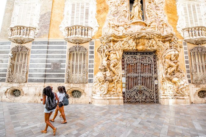 View on the national museum of ceramics and decorative arts with african ethnicity girls walking in Valencia city, Spain