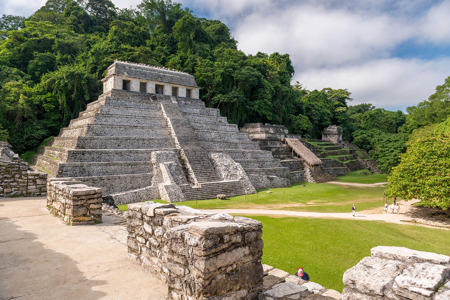 Unidentified people in the mayan temple ruins surrounded by dense jungle in Palenque Mexico